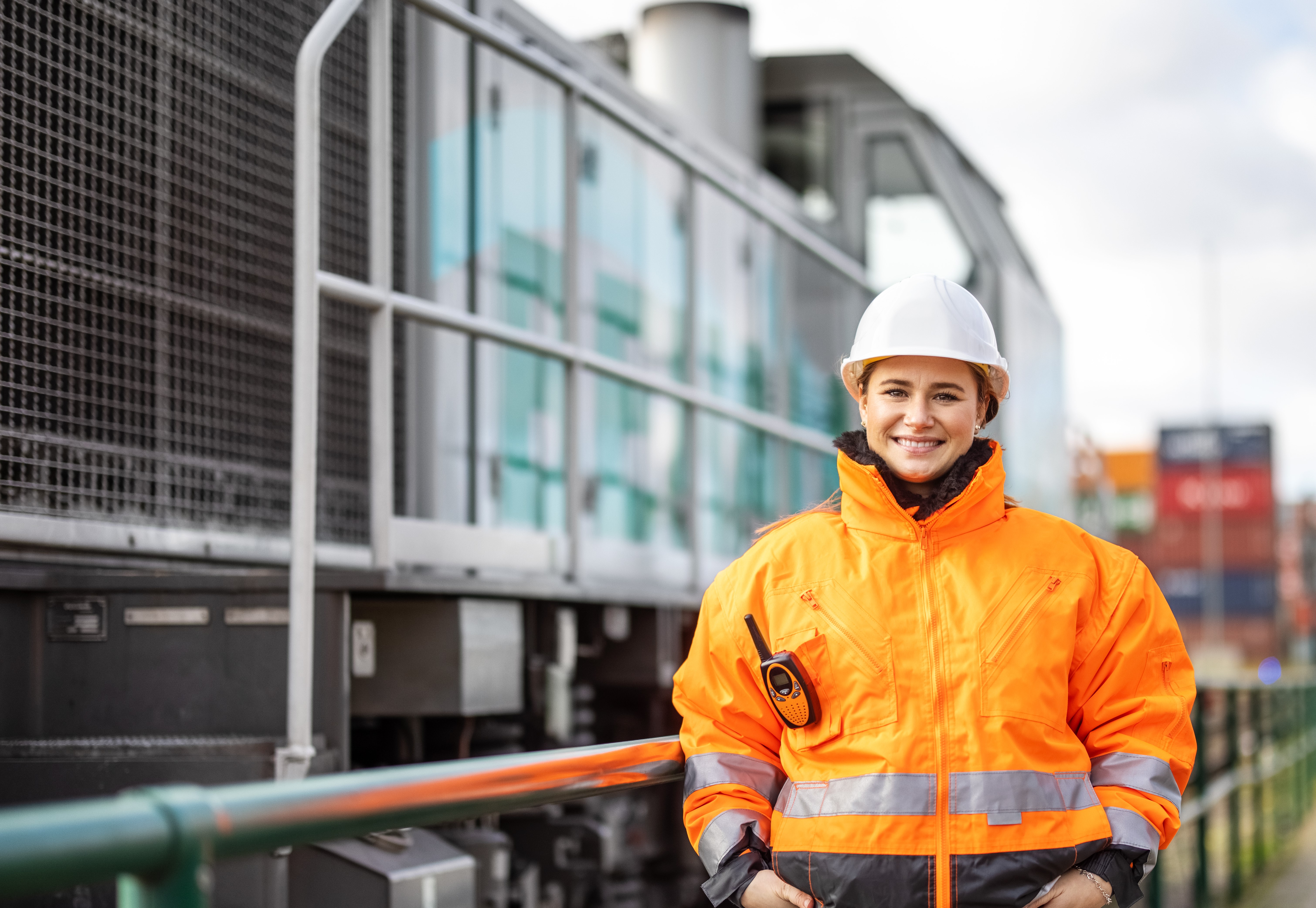 Female rail worker standing in front of freight train